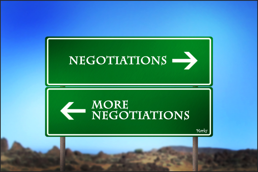 Road sign with arrows pointing and text that says negotiations and more negotiations